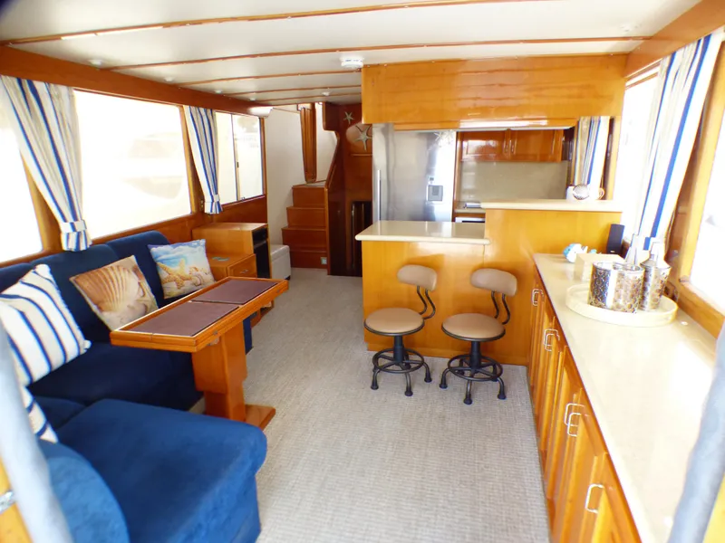 Interior of 1987 MedYacht Mallorca 50 with blue seating and wooden cabinetry.