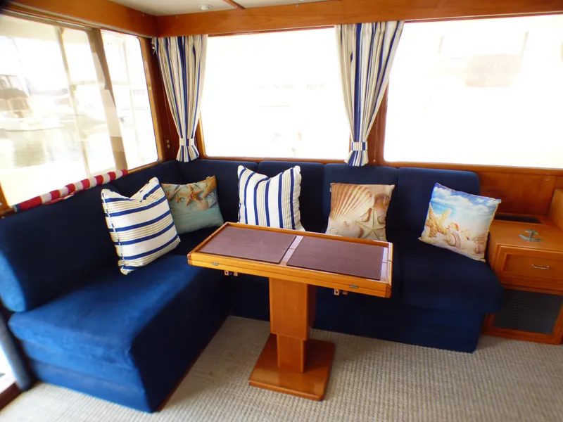 Interior of 1987 MedYacht Mallorca 50 with blue seating and nautical-themed pillows.