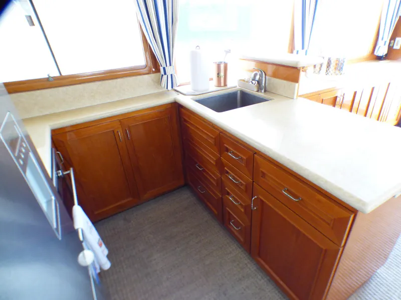 1987 MedYacht Mallorca 50 kitchen with wooden cabinets, countertop, and sink.