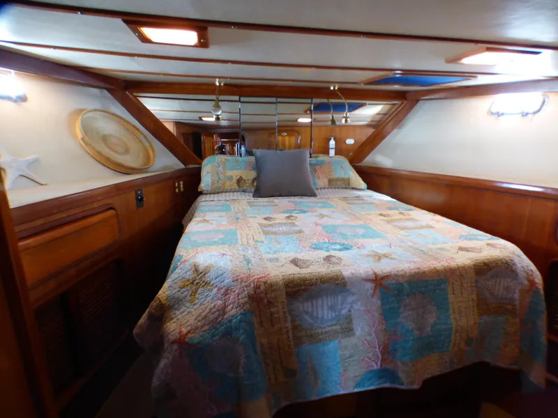 Cozy cabin interior of 1987 MedYacht Mallorca 50 with colorful quilted bedspread.