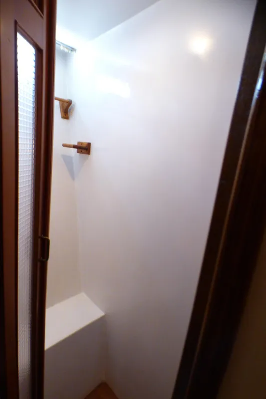 Compact shower area in a 1987 MedYacht Mallorca 50, featuring wooden accents.