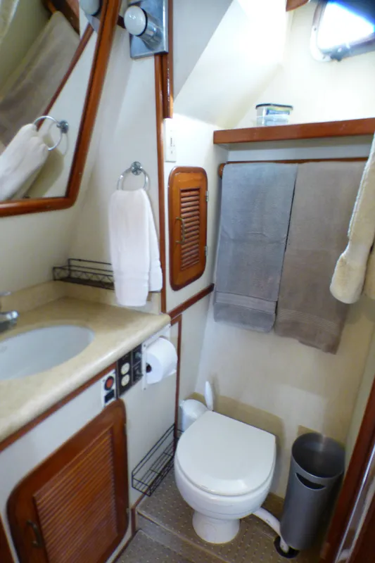 Compact bathroom in 1987 MedYacht Mallorca 50, featuring sink, toilet, and towels.