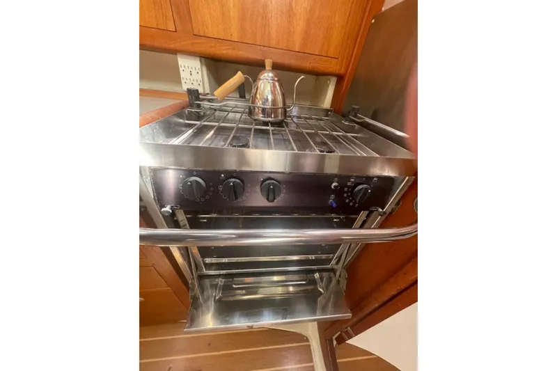 Stainless steel stove with kettle in a 2001 Hunter 380 yacht kitchen.