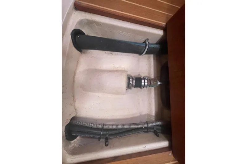 Bilge compartment of a 2001 Hunter 380 sailboat, featuring hoses and fittings.