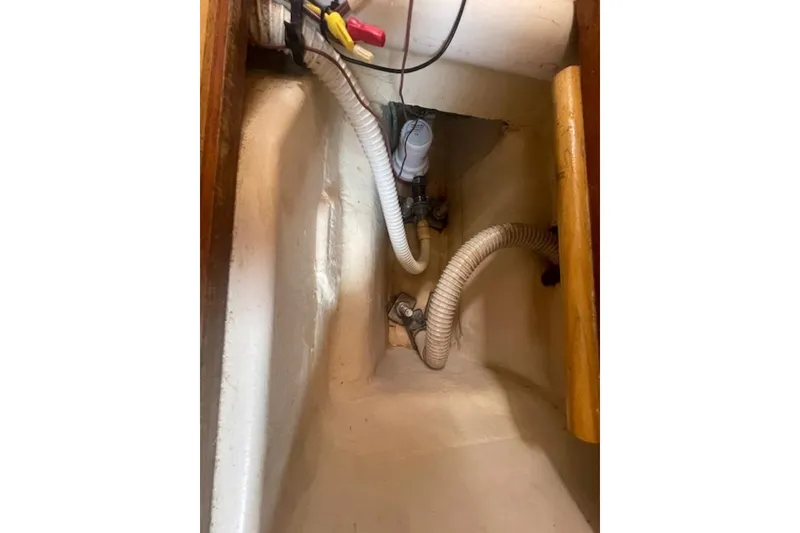 Bilge area of a 2001 Hunter 380 sailboat with hoses and wiring.
