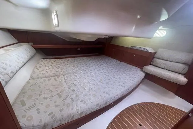 Cozy cabin interior of a 2001 Hunter 380 sailboat with a spacious bed and seating area.