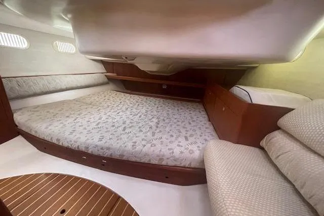 Interior cabin of a 2001 Hunter 380 sailboat with a spacious bed and wooden accents.