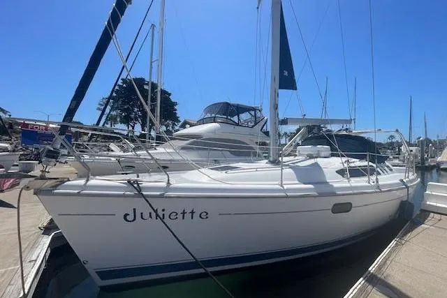 2001 Hunter 380 sailboat named Juliette docked at a marina under clear blue skies.