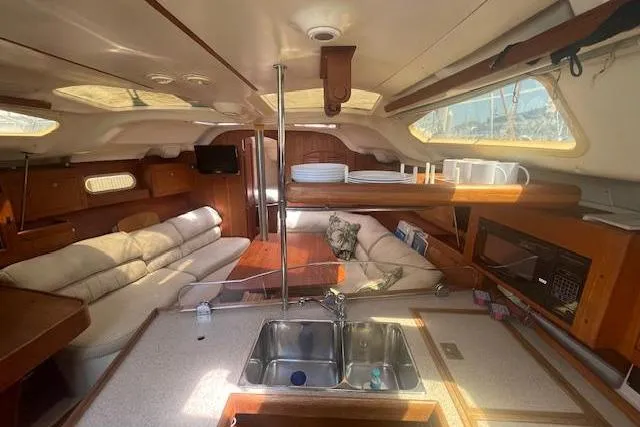 Interior of a 2001 Hunter 380 sailboat with cozy seating and kitchen area.