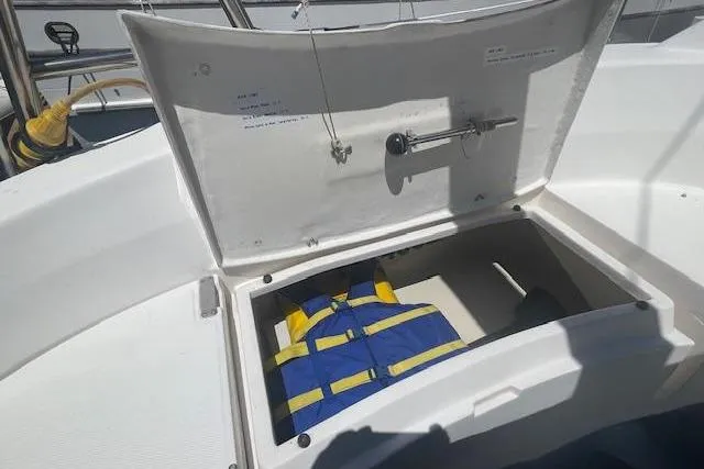 Open storage compartment on 2001 Hunter 380 sailboat with life jackets inside.