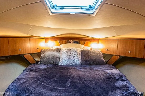 Luxurious cabin interior of 2007 Tiara Yachts 4300 Sovran with plush bedding and ambient lighting.