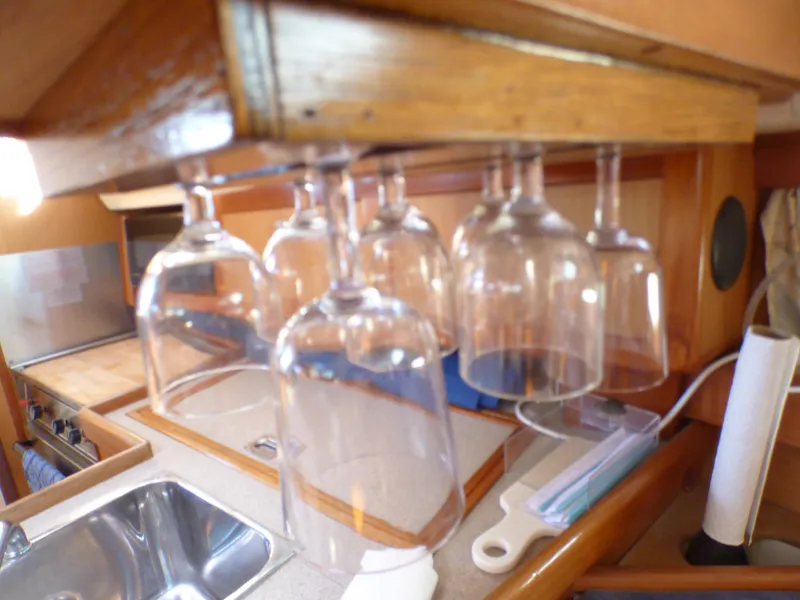 Wine glasses hanging in the galley of a 1998 Hunter 34 yacht.