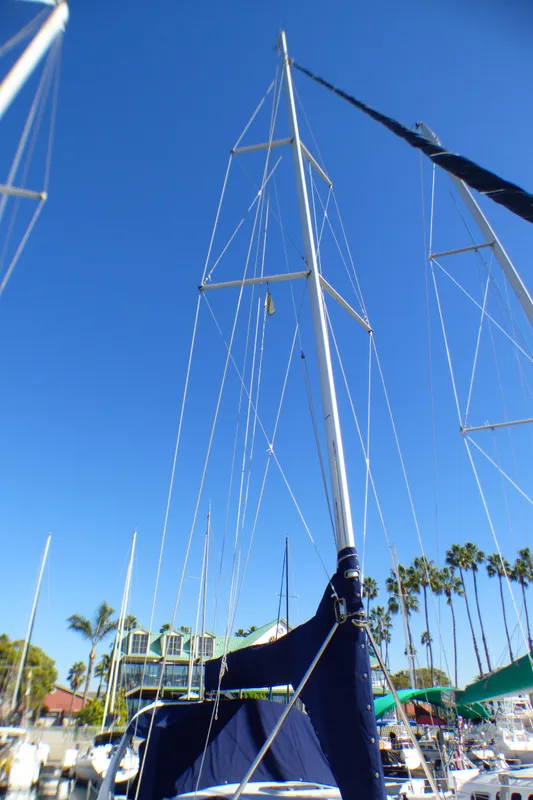 1998 Hunter 34 sailboat in harbor, clear blue sky.