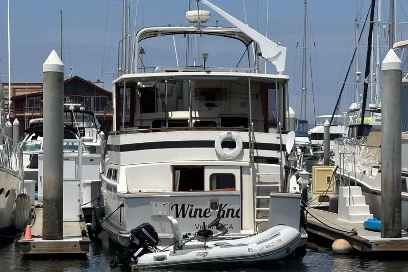 1988 Overseas PT52 Cockpit Motoryacht docked at marina with inflatable boat.