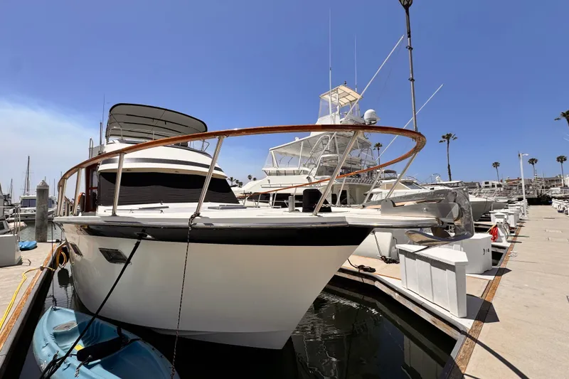 1988 Overseas PT52 Cockpit Motoryacht docked at marina under clear blue sky.