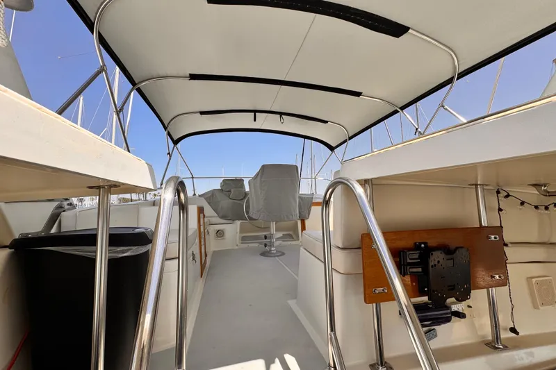 1988 Overseas PT52 Cockpit Motoryacht interior with covered seating and metal railings.