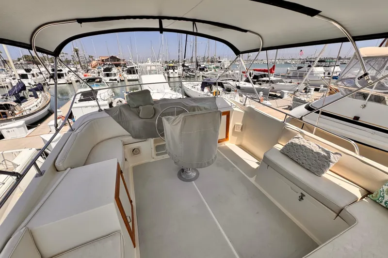 Cockpit view of 1988 Overseas PT52 Motoryacht in marina, featuring seating and helm station.