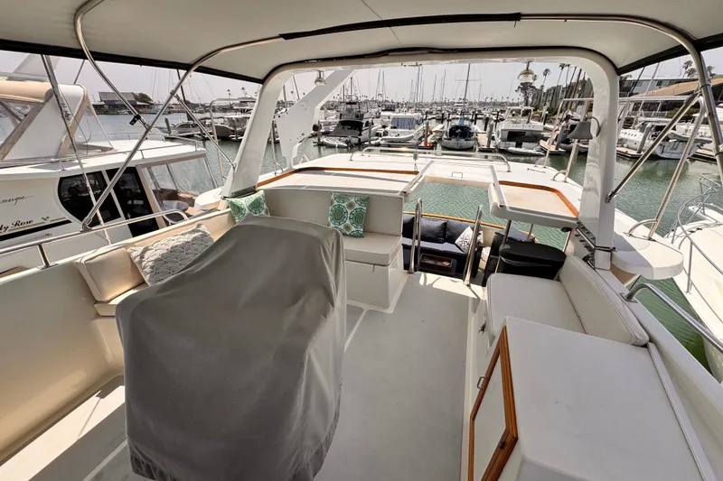 1988 Overseas PT52 Cockpit Motoryacht interior with marina view, featuring seating and covered controls.