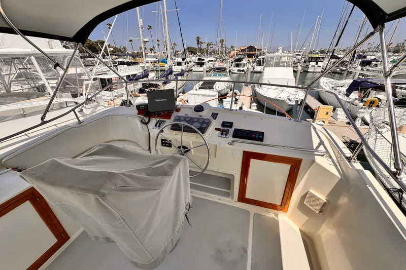 Cockpit view of 1988 Overseas PT52 Motoryacht in marina, featuring helm and navigation equipment.