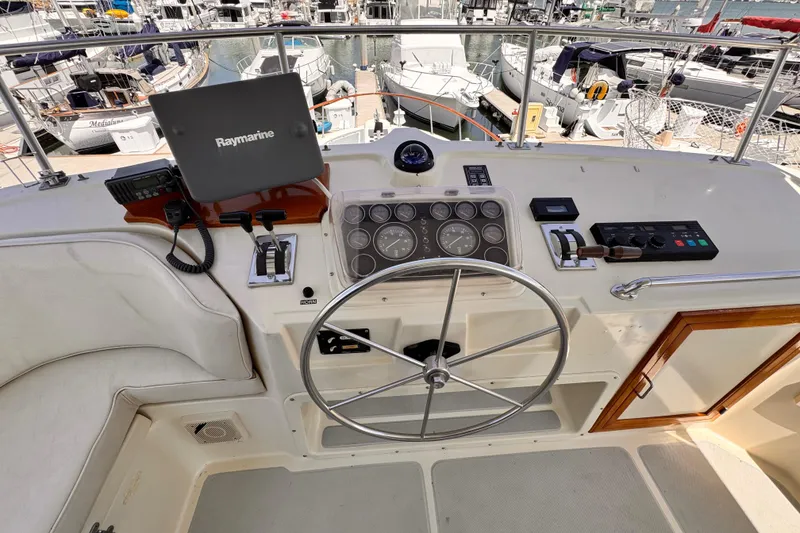 Cockpit of 1988 Overseas PT52 Motoryacht with steering wheel and navigation equipment.
