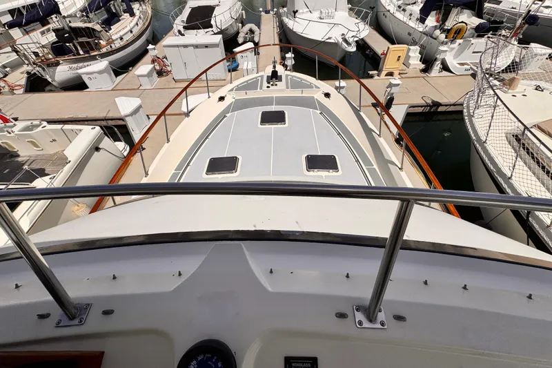 1988 Overseas PT52 Cockpit Motoryacht docked among other boats in a marina.