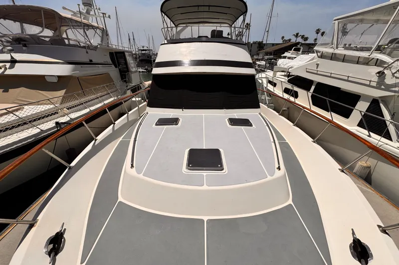 1988 Overseas PT52 Cockpit Motoryacht docked at marina, showcasing spacious deck and sleek design.