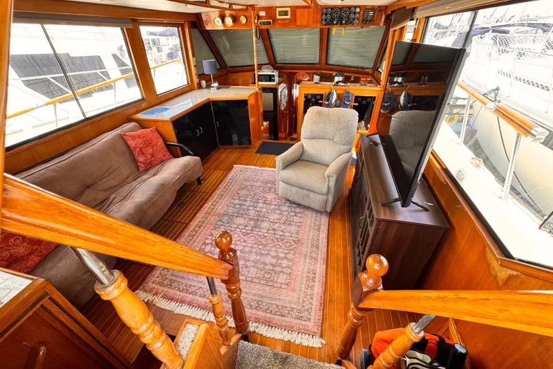 Luxurious 1988 Overseas PT52 Cockpit Motoryacht interior with cozy seating and elegant wood finishes.