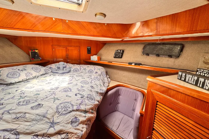 Cozy cabin interior of 1988 Overseas PT52 Cockpit Motoryacht with nautical-themed bedding.