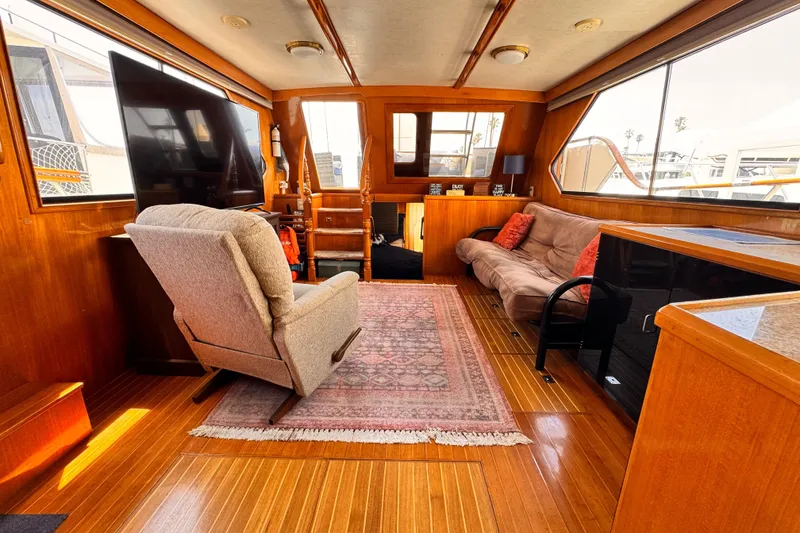 Luxurious 1988 Overseas PT52 Cockpit Motoryacht interior with cozy seating and elegant wood finishes.