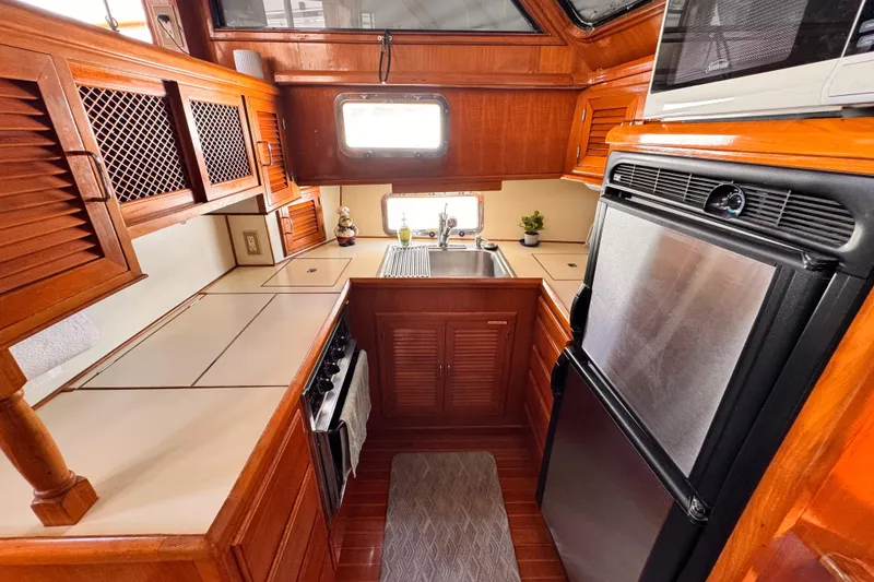 1988 Overseas PT52 Cockpit Motoryacht kitchen with wood cabinetry and modern appliances.