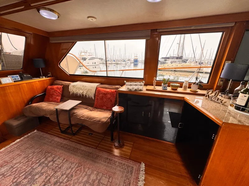 Luxurious 1988 Overseas PT52 yacht interior with cozy seating, large windows, and elegant decor.