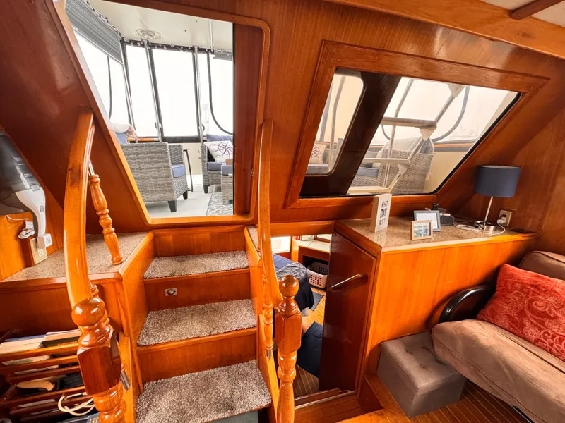 Interior of 1988 Overseas PT52 Cockpit Motoryacht with wooden stairs and cozy seating area.