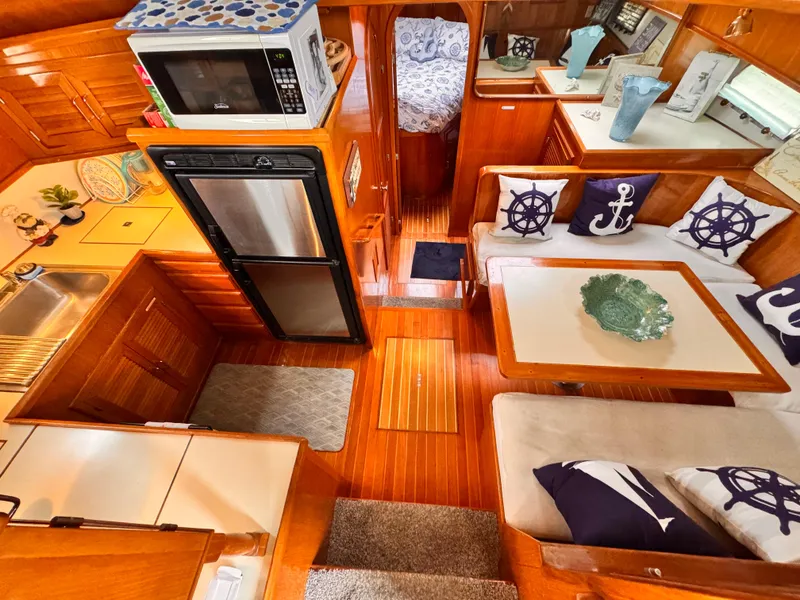 Luxurious 1988 Overseas PT52 yacht interior with cozy seating, nautical decor, and modern kitchen amenities.