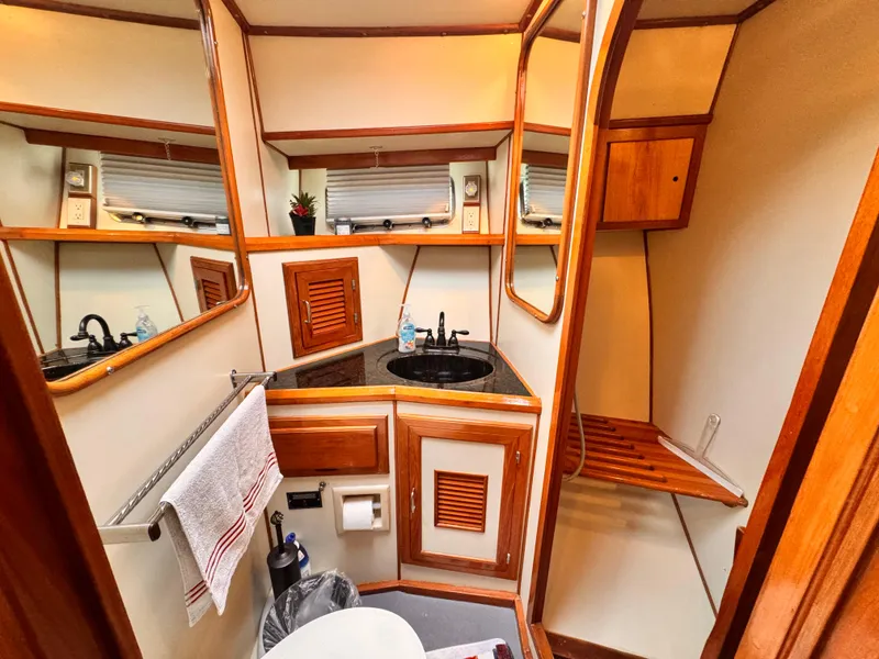 Luxurious 1988 Overseas PT52 yacht bathroom with wood accents and modern amenities.