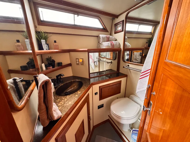Luxurious bathroom in 1988 Overseas PT52 Cockpit Motoryacht with elegant wood accents and modern amenities.