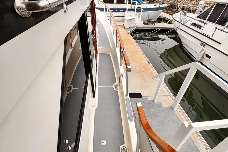 1988 Overseas PT52 Cockpit Motoryacht docked, showcasing side deck and marina view.