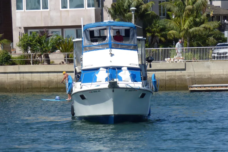 1985 Carver 3607 Aft Cabin Motor Yacht on water near residential area.