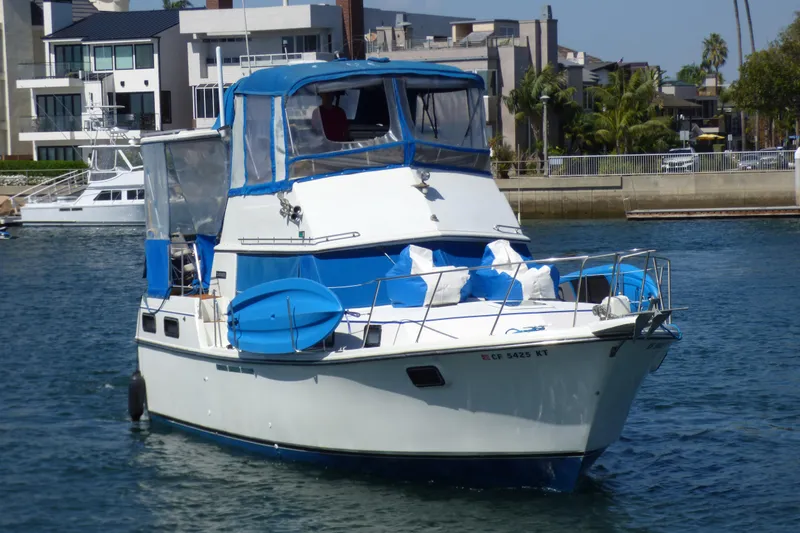 1985 Carver 3607 Aft Cabin Motor Yacht with blue accents docked in a marina.
