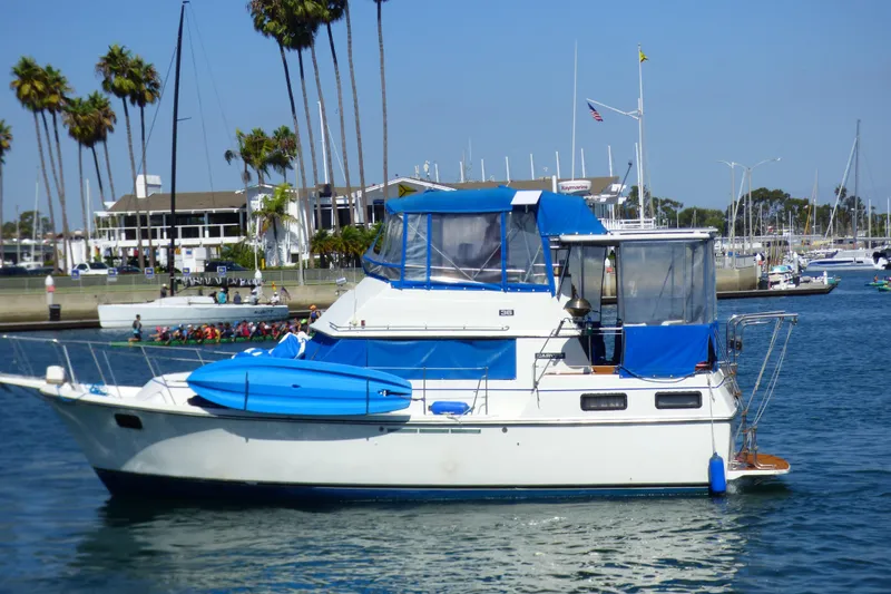 1985 Carver 3607 Aft Cabin Motor Yacht docked in a marina with palm trees.