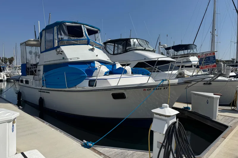1985 Carver 3607 Aft Cabin Motor Yacht docked at marina, for sale sign visible.