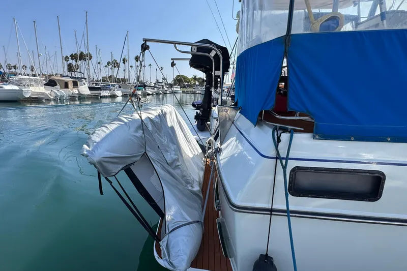 1985 Carver 3607 Aft Cabin Motor Yacht docked with inflatable boat, marina background.