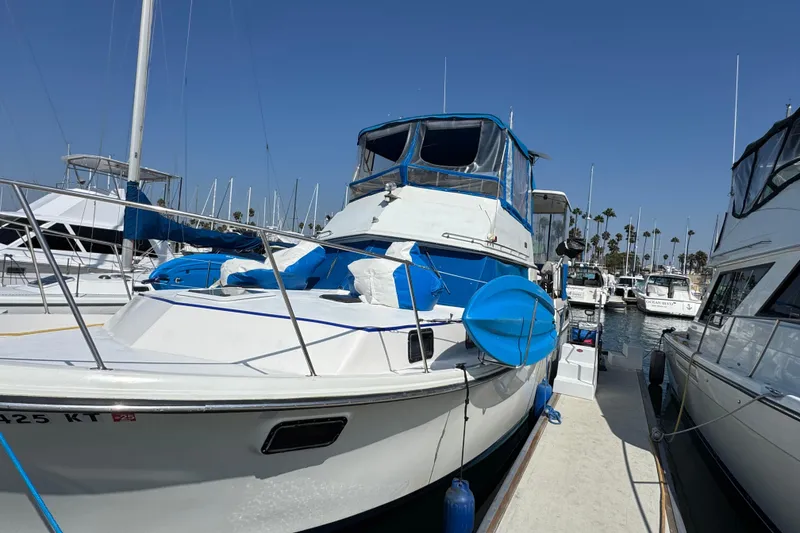 1985 Carver 3607 Aft Cabin Motor Yacht docked at marina under clear blue sky.