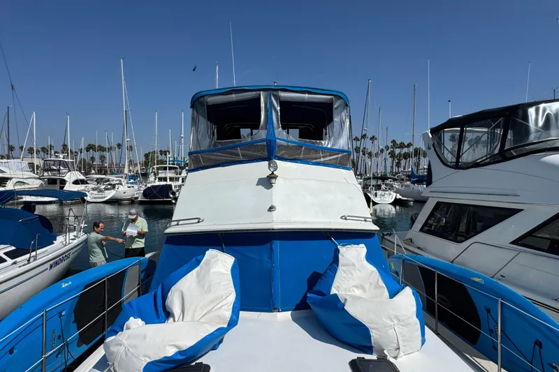 1985 Carver 3607 Aft Cabin Motor Yacht docked in a marina under clear blue skies.