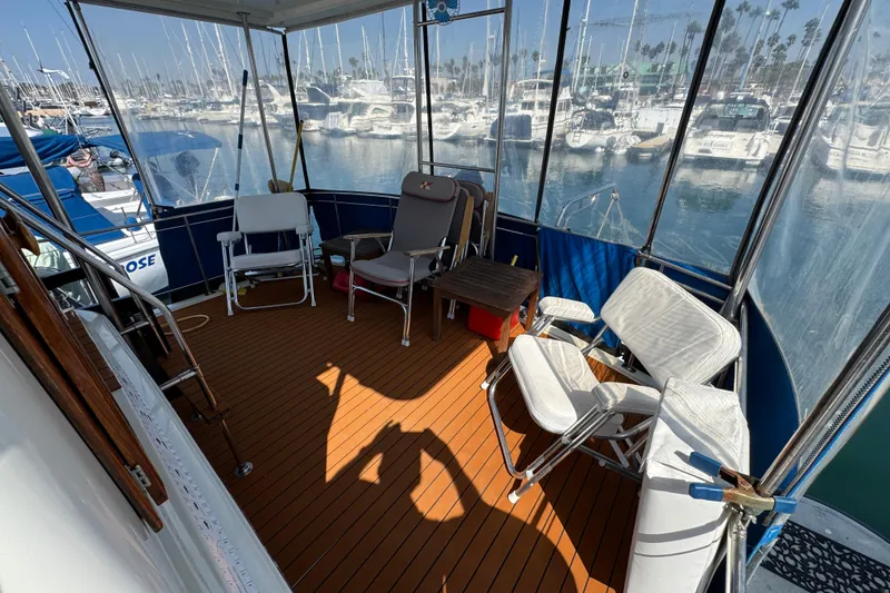1985 Carver 3607 Aft Cabin Motor Yacht deck with chairs and marina view.