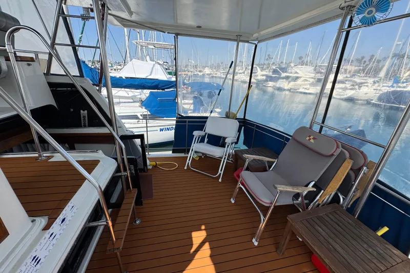1985 Carver 3607 Aft Cabin Motor Yacht interior with seating, docked at marina.