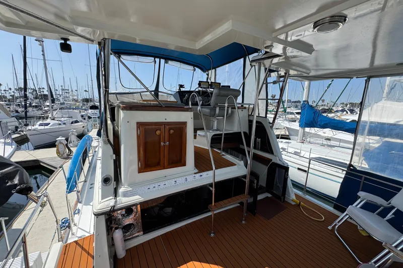 1985 Carver 3607 Aft Cabin Motor Yacht interior with wooden deck and marina view.