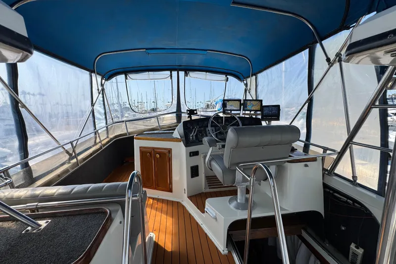 1985 Carver 3607 Aft Cabin Motor Yacht helm with blue canopy and navigation equipment.