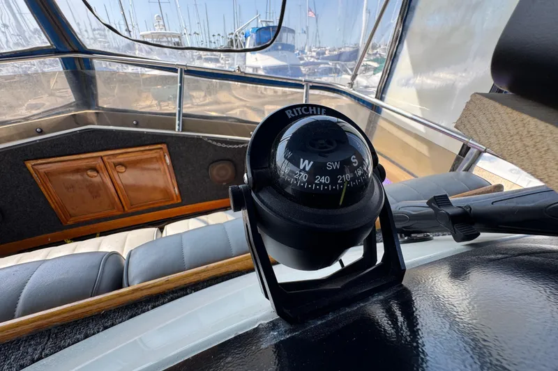 Compass on 1985 Carver 3607 Aft Cabin Motor Yacht, with marina view in background.