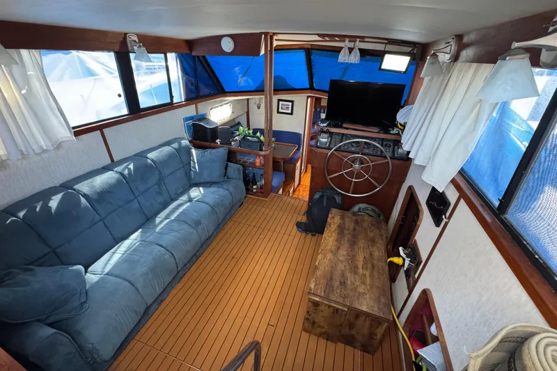 Interior of 1985 Carver 3607 Aft Cabin Motor Yacht with blue sofa and wooden accents.