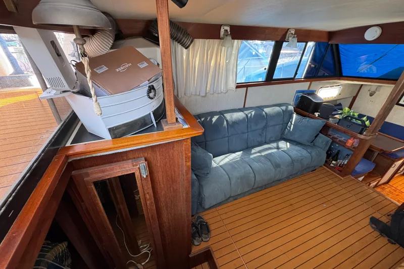 1985 Carver 3607 Aft Cabin Motor Yacht interior with sofa and wooden flooring.